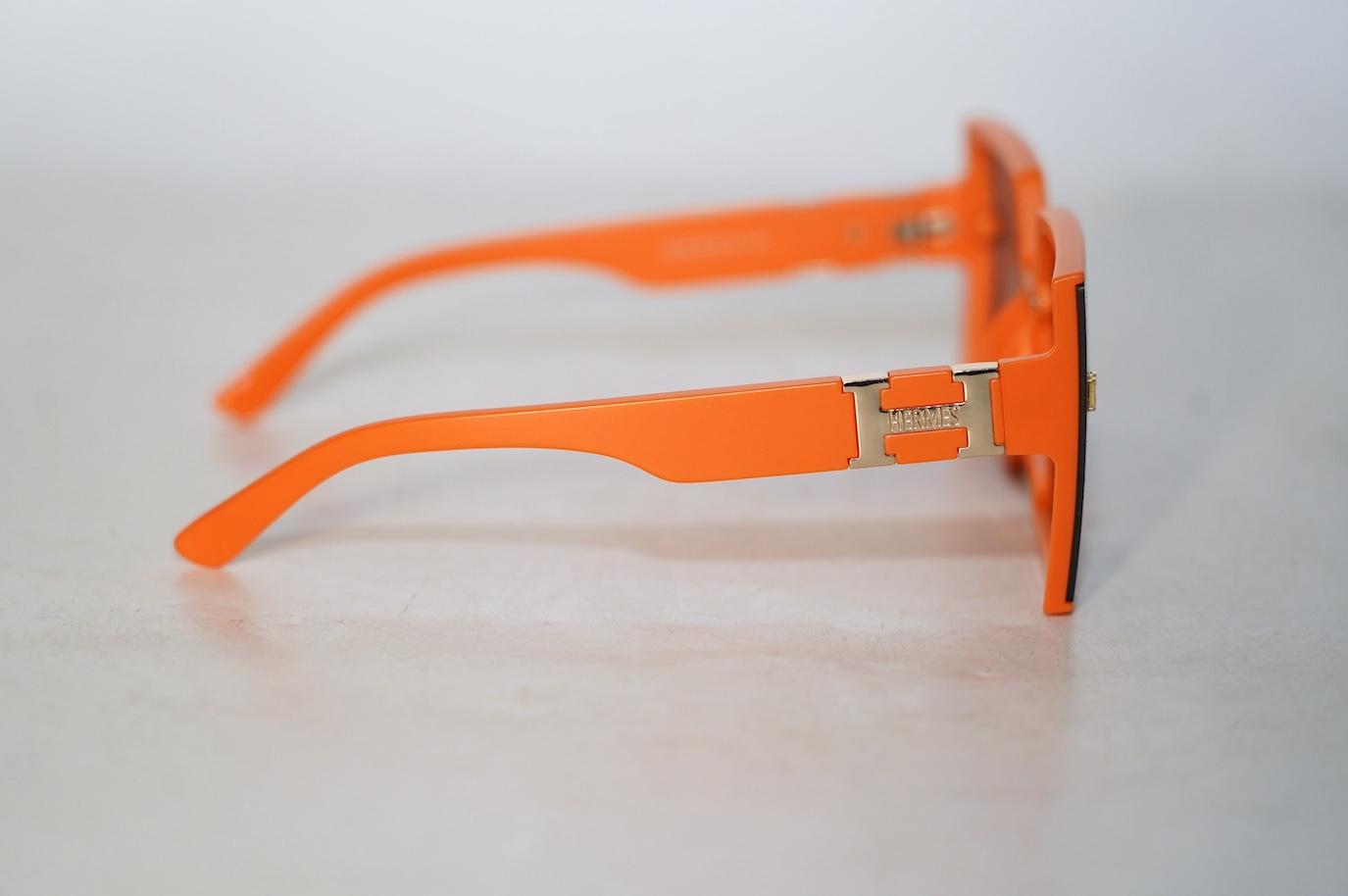 A pair of orange Hermes sunglasses